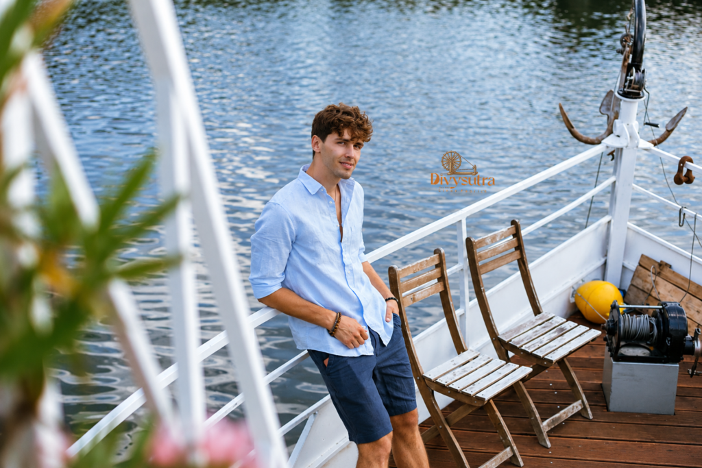 Man wearing a light blue linen shirt on a boat deck